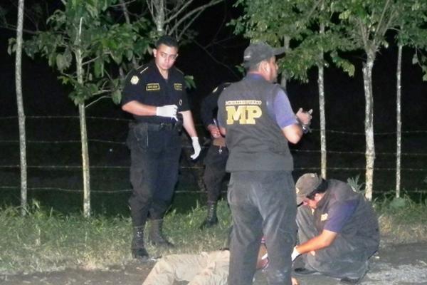 Fiscales del Ministerio Público y agentes de la Policía buscan evidencias en el lugar del crimen ocurrido en Izabal. (Foto Prensa Libre: Edwin Perdomo)<br _mce_bogus="1"/>