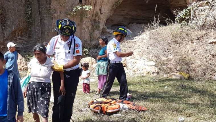 Bomberos auxilian a una de las mujeres que resultó herida al derrumbarse una cueva en Jalapa. (Foto Prensa Libre: Hugo Oliva).
