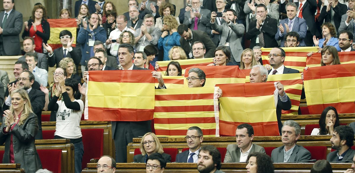 Diputados del PPC muestran banderas españolas y catalanas este lunes. (Foto Prensa Libre: EFE).