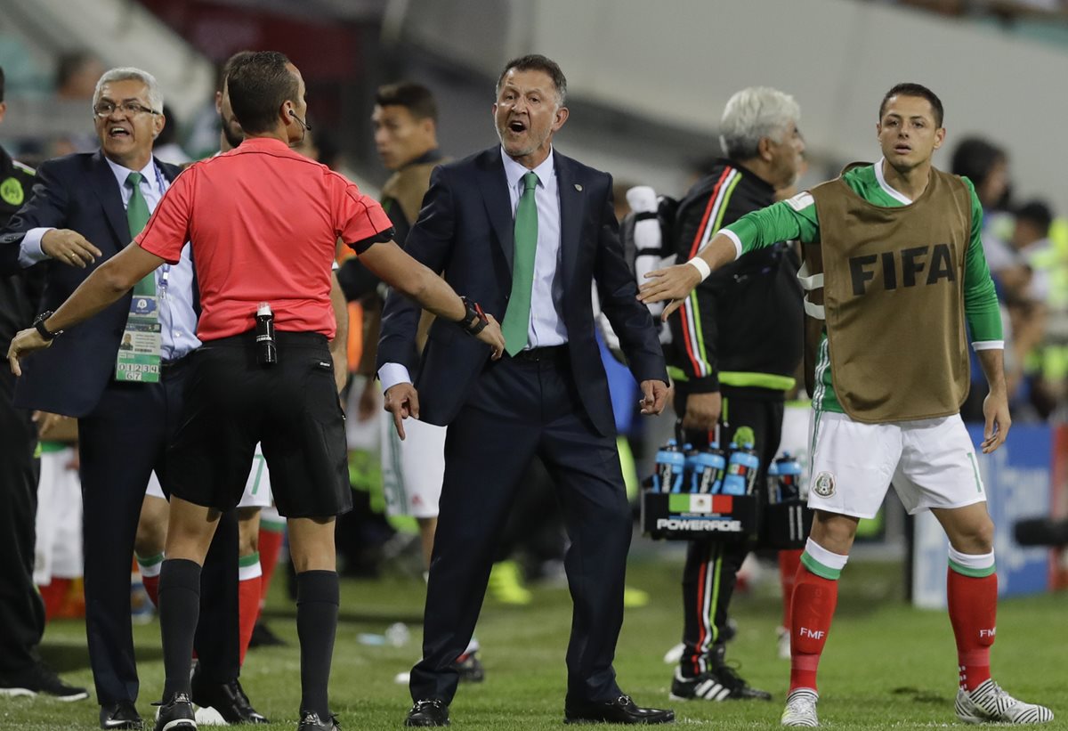 Los jugadores detienen a Osorio mientras encara al árbitro asistente. (Foto Prensa Libre: AP)