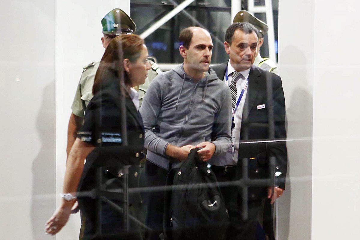 Sergio Jadue captado en elaeropuerto de Santiago el pasado 17 de noviembre mientras es escoltado por la policía para abordar un avión rumbo a Miami. (Foto Prensa Libre: EFE)