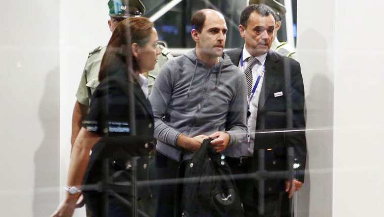 Sergio Jadue captado en elaeropuerto de Santiago el pasado 17 de noviembre mientras es escoltado por la policía para abordar un avión rumbo a Miami. (Foto Prensa Libre: EFE)