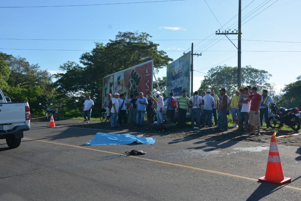 Vecinos observan el cuerpo de Víctor Rafael Monroy, quien murió al chocar en motocicleta contra automóvil, en ruta a Iztapa, Escuintla. (Foto Prensa Libre: Enrique Paredes)