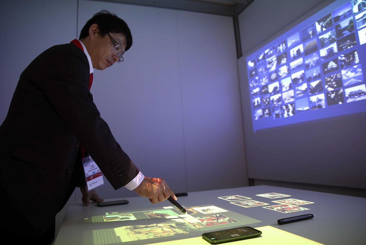 Demostración de Fujitsu de un software que permite la utilización de cualquier superficie como ampliación de la pantalla táctil de un dispositivo móvil. (Foto Prensa Libre: EFE).