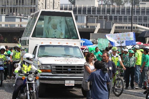 Papamóvil con imagen de San Juan Pablo II encabeza marcha frente a la comuna capitalina.