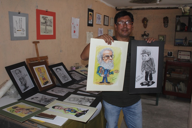 El artista plástico Marvin Eliseo Vásquez García muestra algunos de los retratos que ha hecho a quetzaltecos y a otros personajes. (Foto Prensa Libre: Fred Rivera)