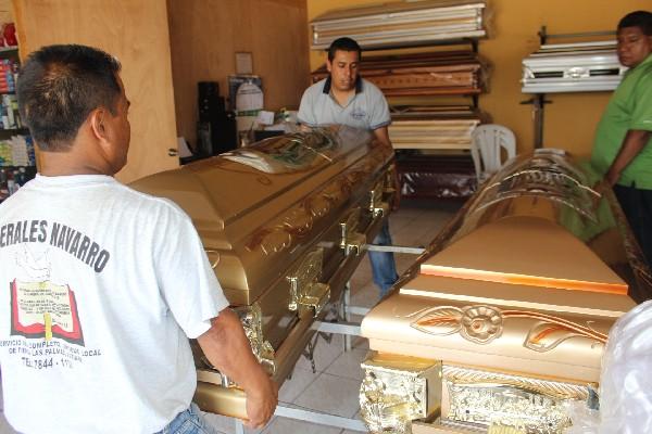 Empleados de funeraria trasladan ataúdes   de la pareja.