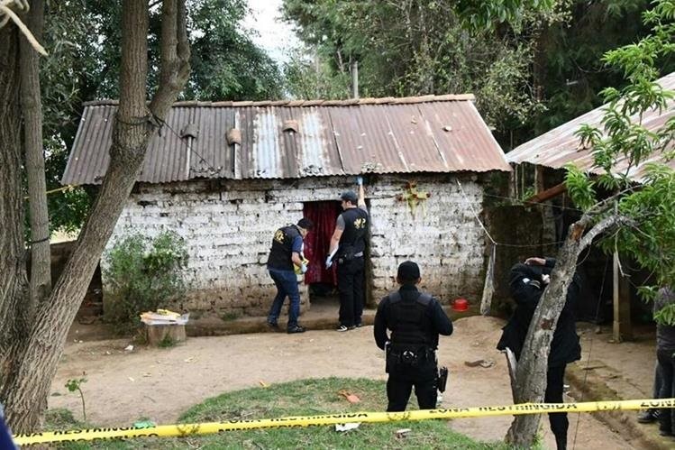 Fiscales del Ministerio Público revisan la vivienda en que fue encontrada Hetnéa y sus dos hijos muertos en el caserío Los Cerritos. (Foto Prensa Libre: Cortesía)