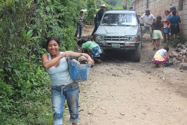 Mujeres y niñas  acarrean piedras y cemento.
