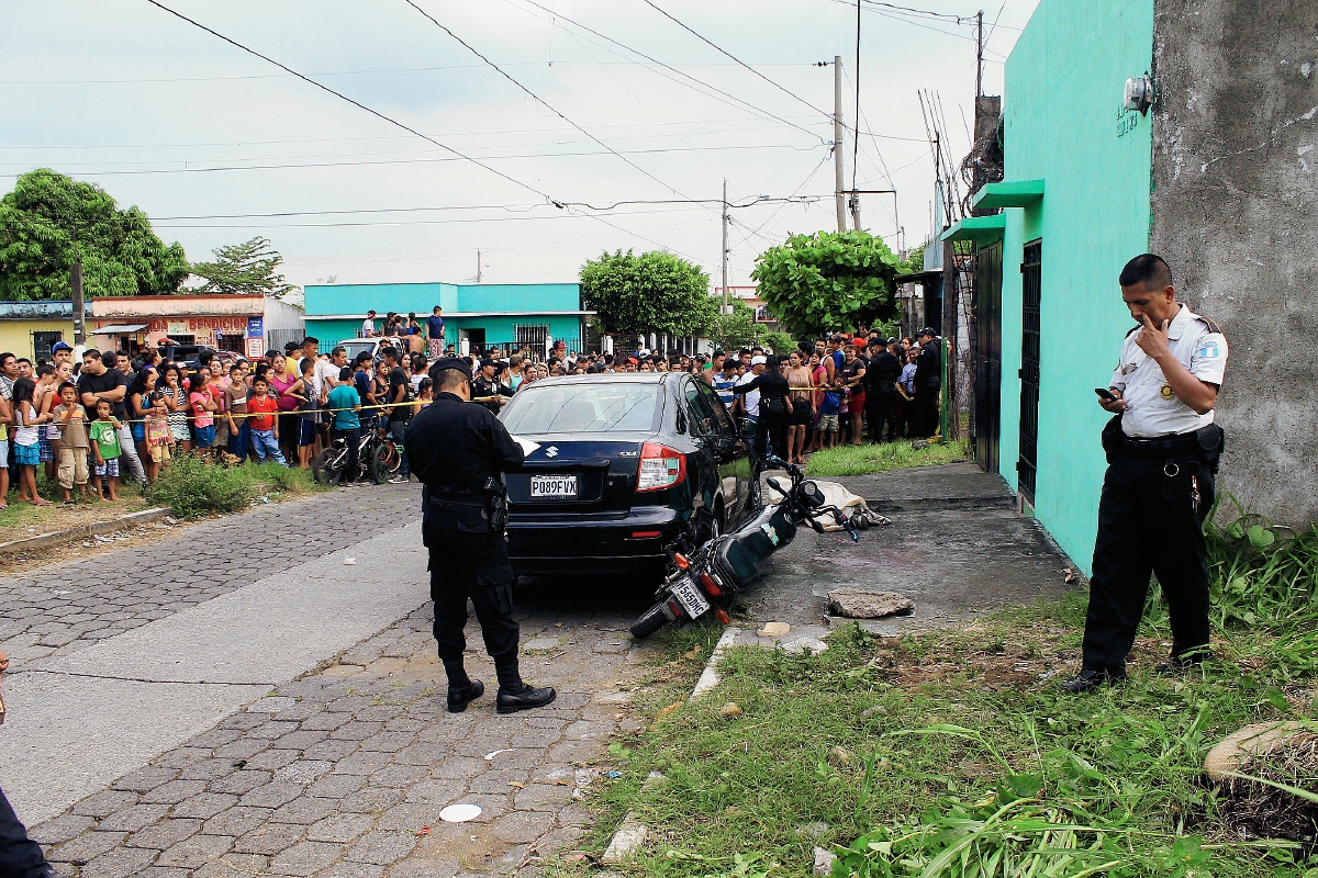 Vecinos y autoridades en el lugar donde muere baleado hombre y adolescente resulta herido, en la ciudad de Escuintla. (Foto Prensa Libre: Enrique Paredes)