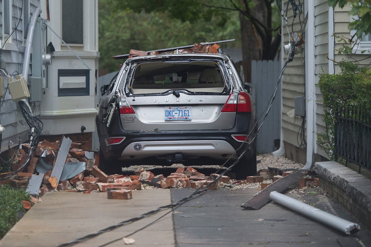 Un carro destruido por la caída de blocs y ladrillos que dejó el paso del huracán Florence. (Foto Prensa Libre: AFP)