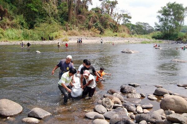 Vecinos sacan  cadáver de río.