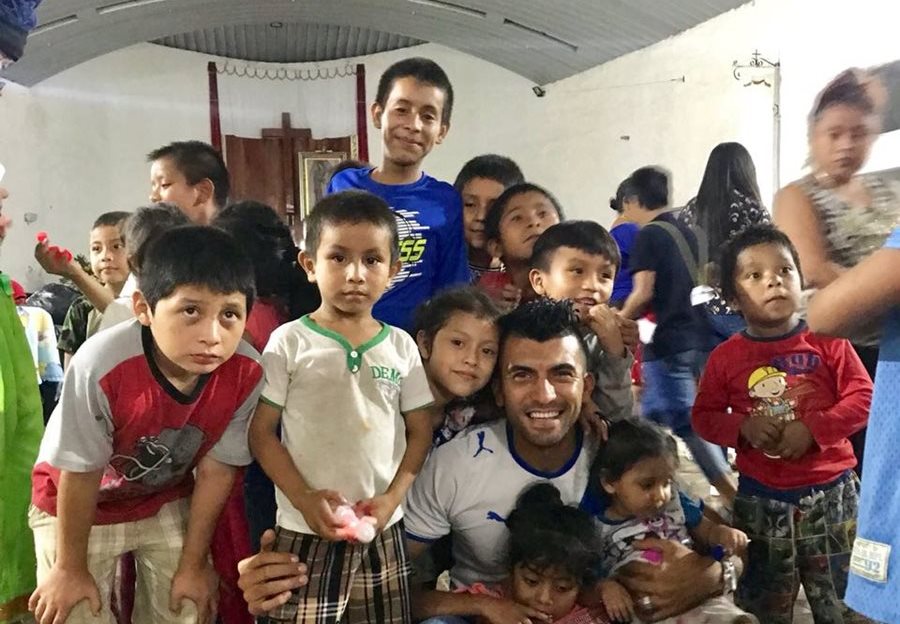El futbolista Cristian Noriega sonríe junto a un grupo de niños en el albergue de Escuintla, donde entregaron víveres y compartieron varias dinámicas con los pequeños. (Foto Prensa Libre: Cortesía Cristian Noriega)