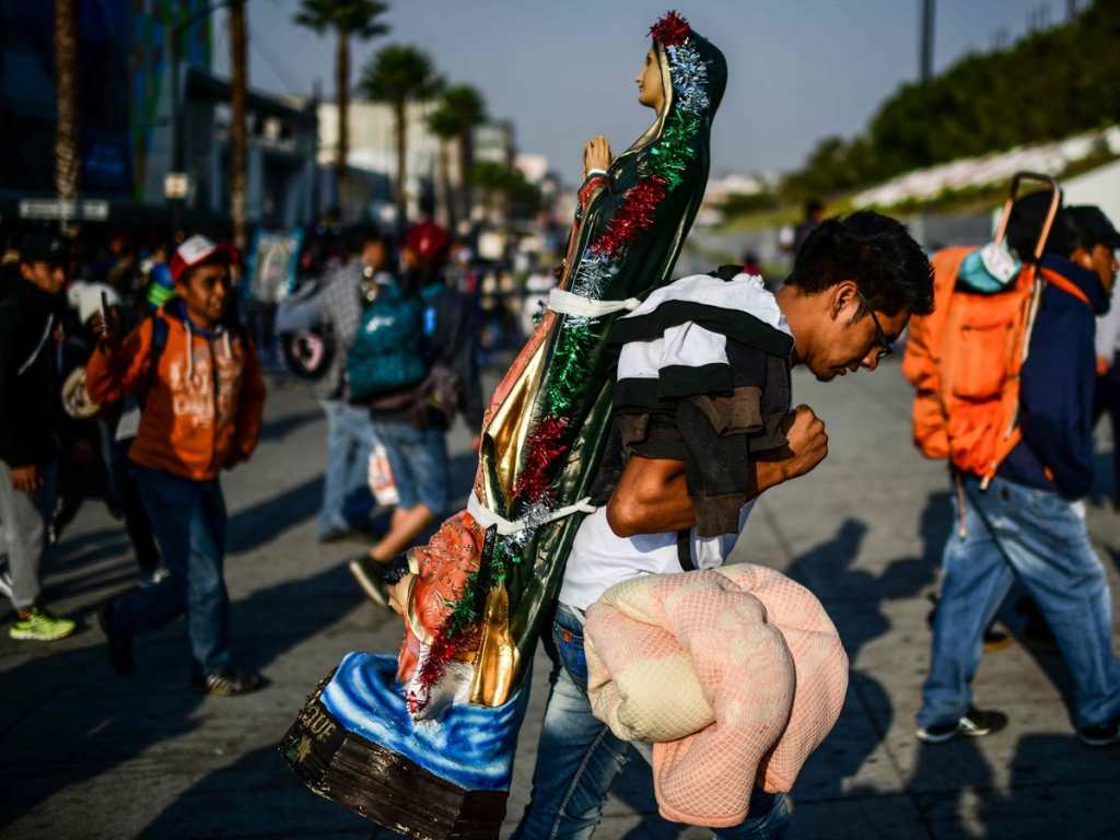 Un feligrés carga en su espalda una estatua de la Virgen de Guadalupe como una muestra de ofrenda para la Virgen.