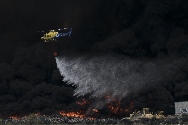 Un helicóptero participa en apagar el fuego en la localidad de Seseña,Madrid. (AFP).