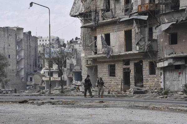 Soldados del ejército sirio patrullan las calles de Ansari, al este de Alepo. (Foto Prensa Libre: AP)