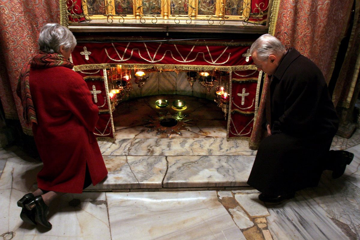 Peregrinos rezan ante la gruta donde se ubica el lugar del pesebre del nacimiento del niño Jesús, en Belén. (Foto: EFE)