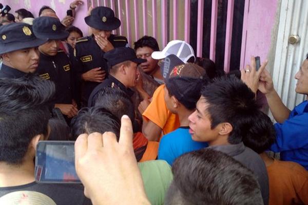 Atenges de la PNC de la cabecera de Jalapa dialogan con vendedores de mercado municipal para que les dejen capturar a Nelson Armando Armando Mateo Martínez (de playera café), acusado de robarle dinero a una mujer. (Foto Prensa Libre: Hugo Oliva) 