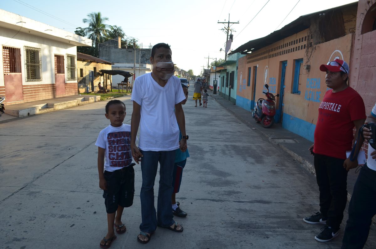 Willian Yovany Reyes Esperias camina junto a sus hijos por una de las calles de Champerico, Retalhuleu. (Foto Prensa Libre: Jorge Tizol)