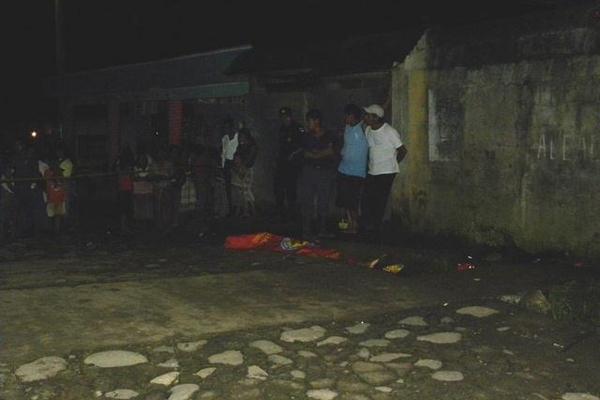 Curiosos permanecen en el lugar donde murió baleado Rigoberto Velásquez, en San Antonio Suchitepéquez. (Foto Prensa Libre: Omar Méndez)