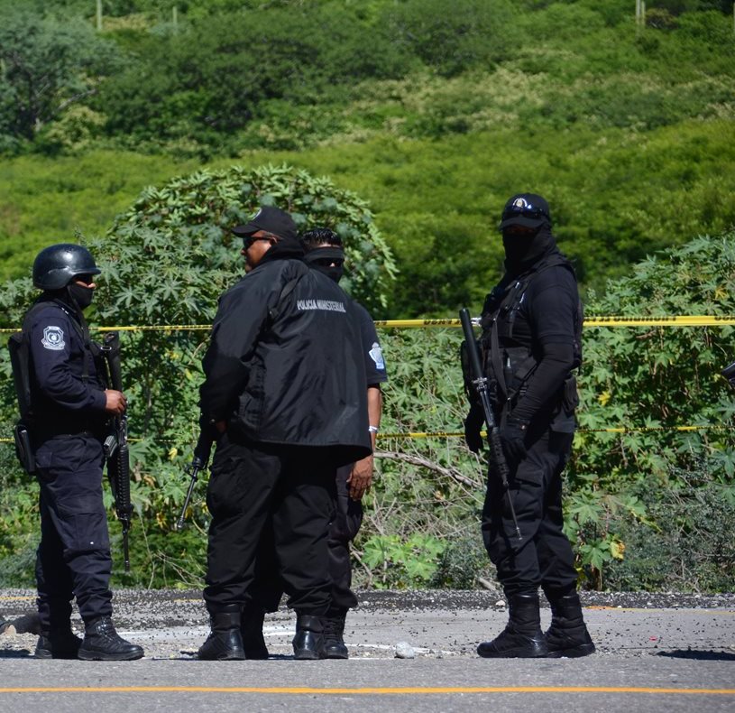 Policías resguardan el área donde fueron hallados los cadáveres de los cinco jóvenes. (Foto Prensa Libre: EFE).