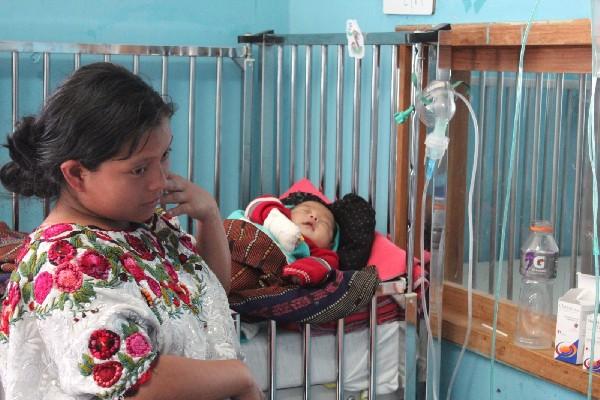 una Madre  cuida a su bebé en el hospital de Sololá, mientras este se restablece de  neumonía.