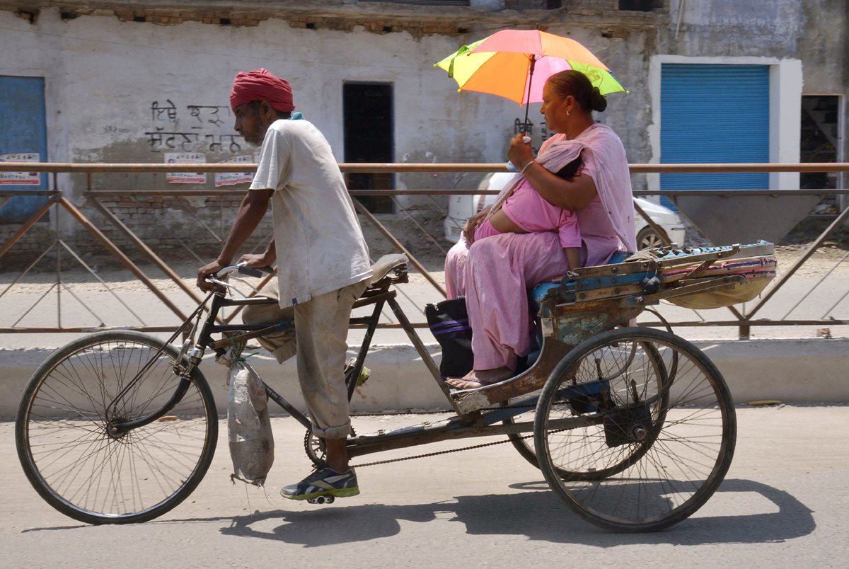 Una mujer protege a su bebé del intenso calor registrado en los últimos días en la India. (Foto Prensa Libre: AFP).