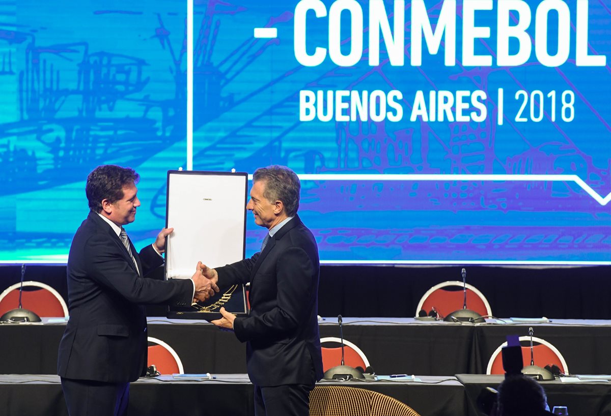 Macri (der.), es condecorado por el presidente de la Conmebol, Alejandro Domínguez. (Foto Prensa Libre: DPA)