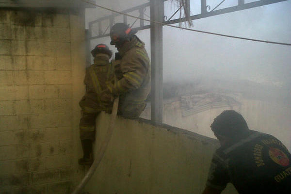 Bomberos intentan sofocar incendio en bodega de la zona 8. (Foto Prensa Libre: CVB)<br _mce_bogus="1"/>