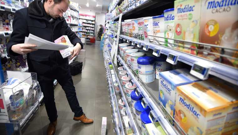 Un empleado de la Dirección General de Competencia, Política de Asuntos del Consumidor y Control del Fraude de EEUU verifica los productos lácteos para bebés en una farmacia. (AFP).