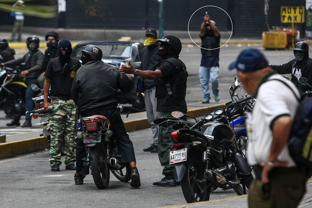 Un grupo de supuestos civiles encapuchados impiden el paso de manifestación en Caracas. (Foto Prensa Libre: EFE)