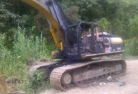Una de las  retroexcavadoras que fueron rociadas con combustible y quemadas por una turba.