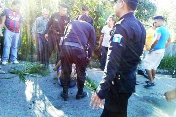 Agentes y  vecinos atienden a  adolescente que fue vapuleada y quemada el lunes último, en Nueva  Santa Rosa. (Foto Prensa Libre: Oswaldo Cardona)