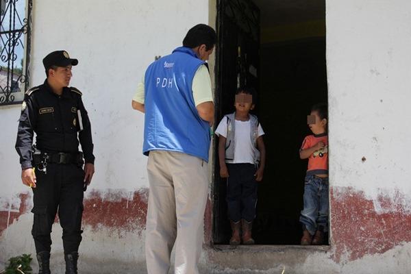 Empleado de la PDH conversa con dos de los niños que fueron abandonados por su madre. (Foto Prensa Libre: Mike Castillo)