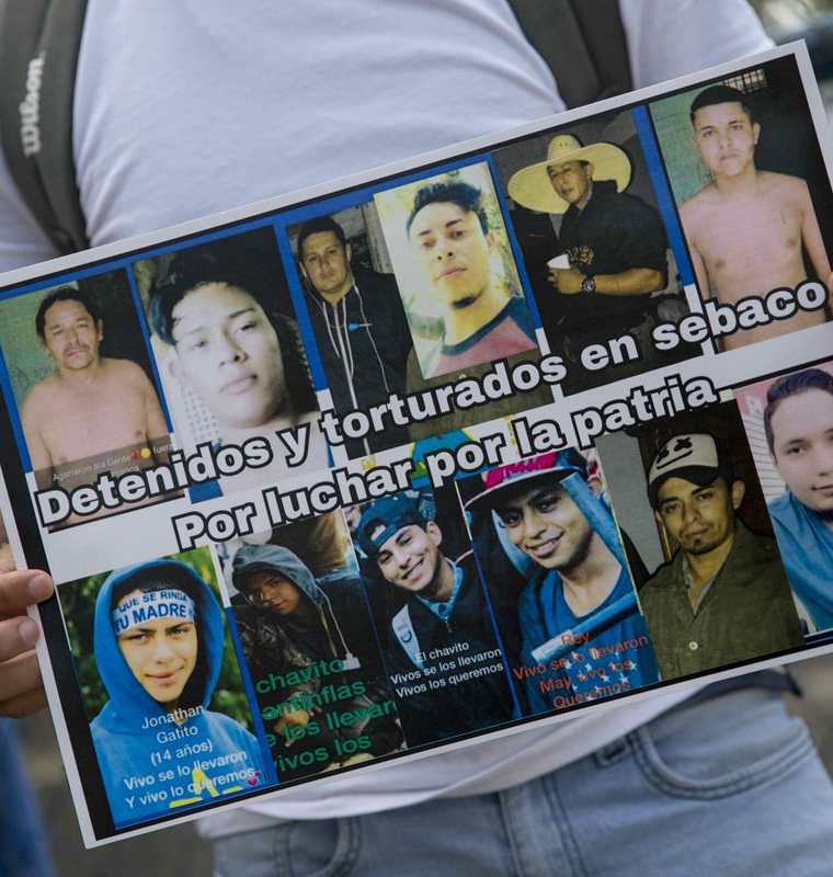 Un nicaragüense sostiene un cartel con fotografías de detenidos, durante un plantón en la cárcel conocida como el Chipote, en Managua, Nicaragua. (EFE)