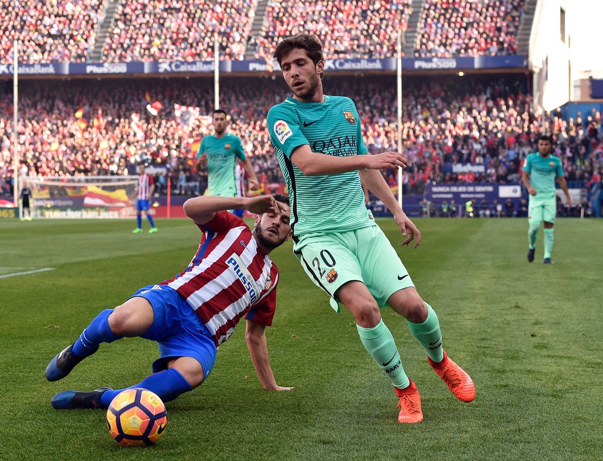 Koke y Sergi Roberto pelean por el balón en el partido disputado en el Vicente Calderón. (Foto Prensa Libre: AFP)