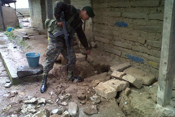 Un soldado muestra una de las grietas que afecta a las viviendas en San Miguel Ixtahuacán, San Marcos. (Foto Prensa Libre: Aroldo Marroquín)