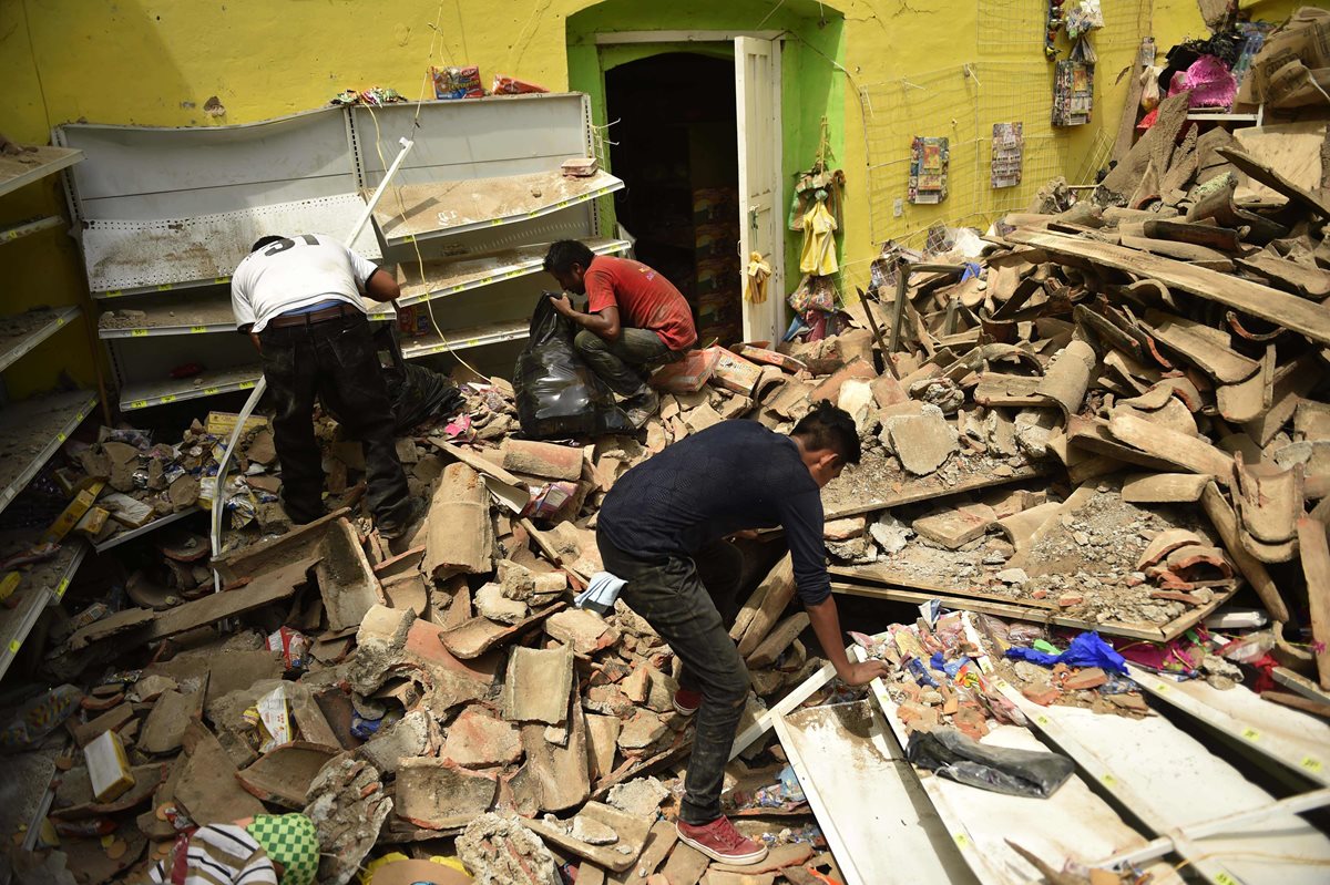 Pobladores tratan de rescatar algunas de sus pertenencias entre los escombros que dejó el terremoto en Juchitán de Zaragoza, Oaxaca, México. (Foto Prensa Libre: AFP).