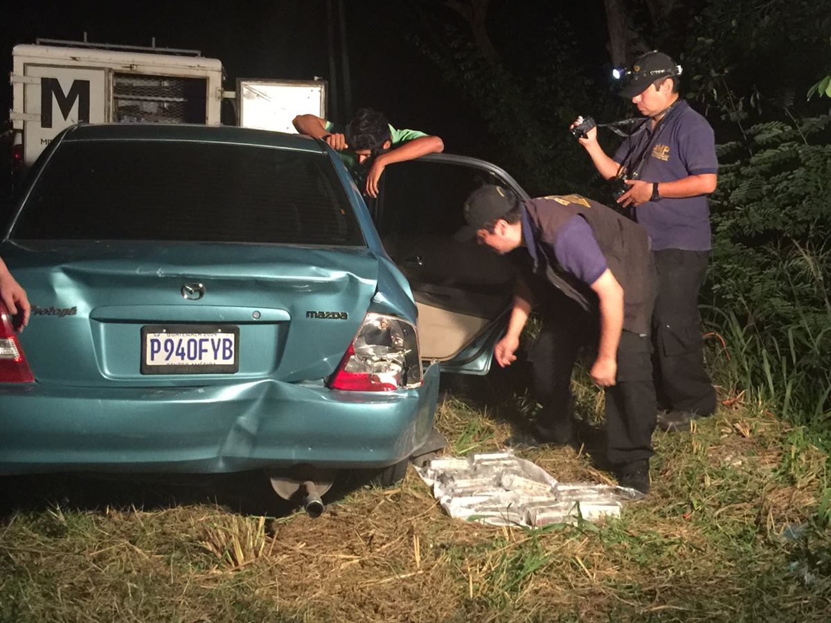 Autoridades del MP registran el vehículo en el que se hallaron los paquetes. (Foto Prensa Libre: Cortesía)