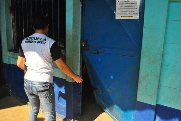 Maestra de la Escuela Armenia Ortiz, de San Martín Zapotitlán, Retalhuleu, muestra una puerta que fue forzada por ladrones. (Foto Prensa Libre: Jorge Tizol)