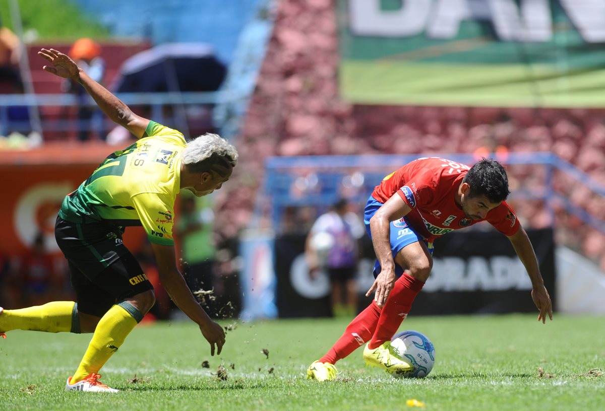Alexis Matta, conduce el balón ante la presión de Cristhian Reyes, de Guastatoya.