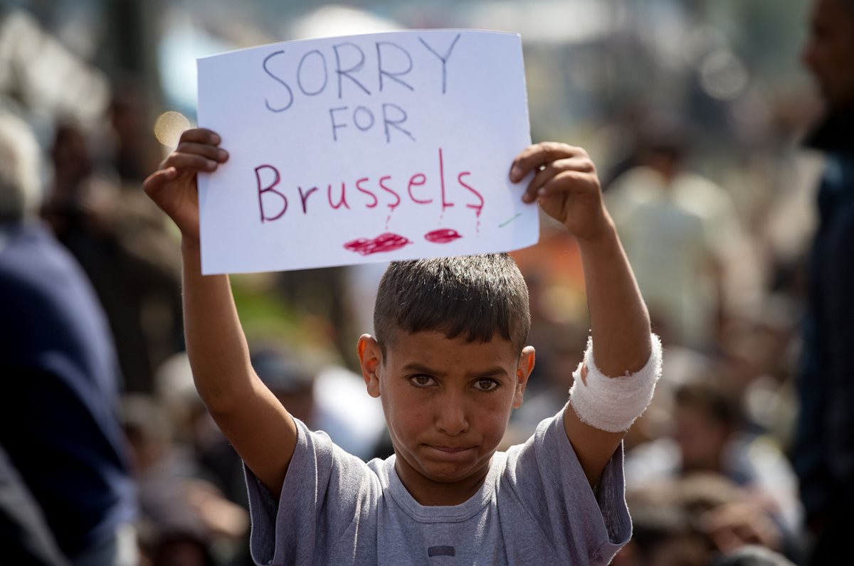 El niño expresa su solidaridad con las víctimas de los ataques terroristas en Bruselas en la frontera entre Grecia y Macedonia, cerca de Idomeni. (Foto Prensa Libre: AFP).