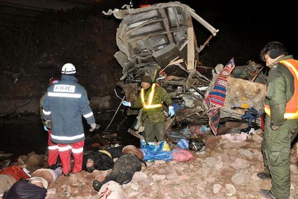 Equipos de rescate trabajan entre los escombros y los cadáveres luego de un accidente de un autobús entre Cochabamba y Potosí, Bolivia. (Foto Prensa Libre: AFP).