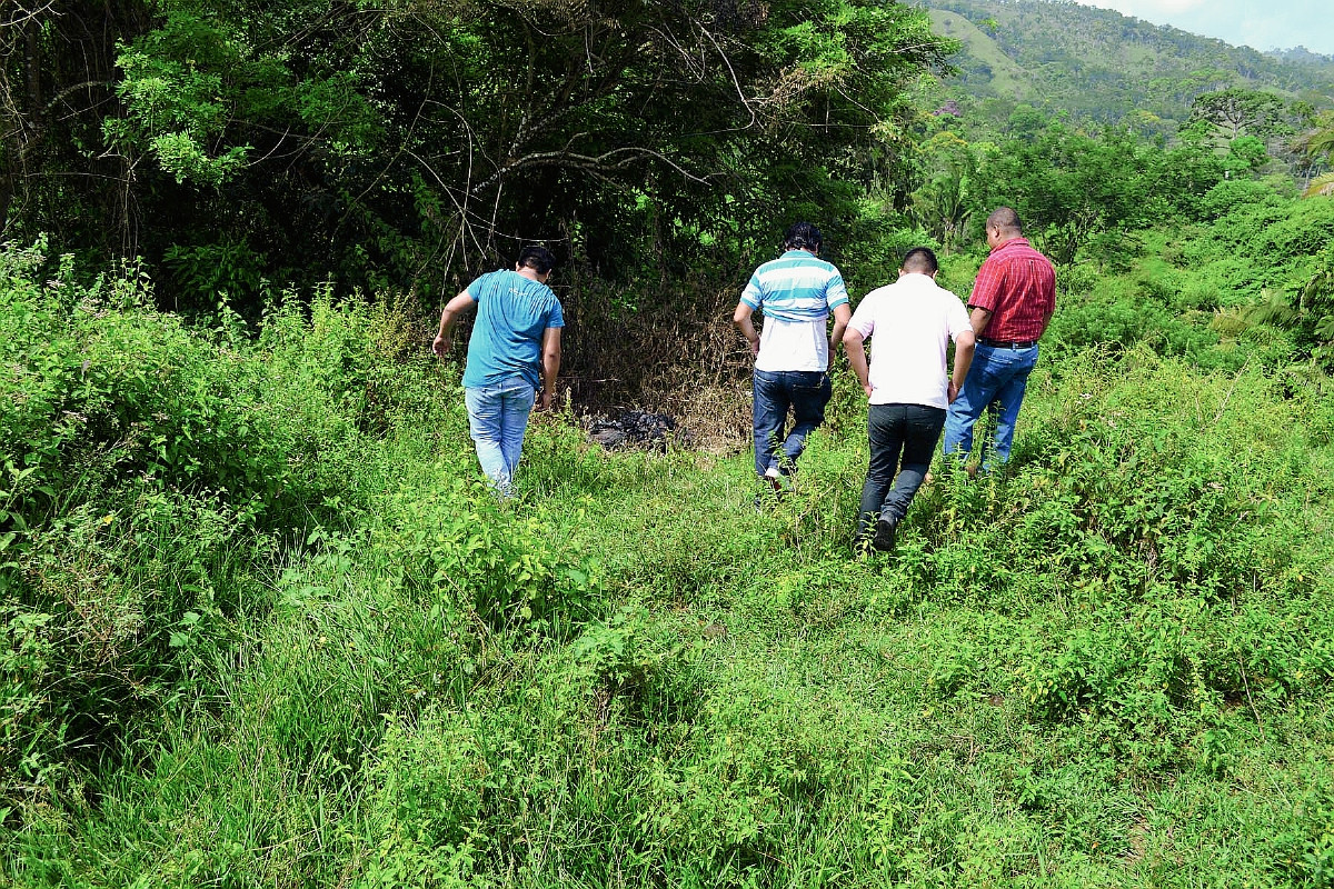 Vecinos de la aldea El Tamarindal, Puerto Barrios, Izabal, caminan por el área donde encontraron un cadáver calcinado. (Foto Prensa Libre: Edwin Perdomo)