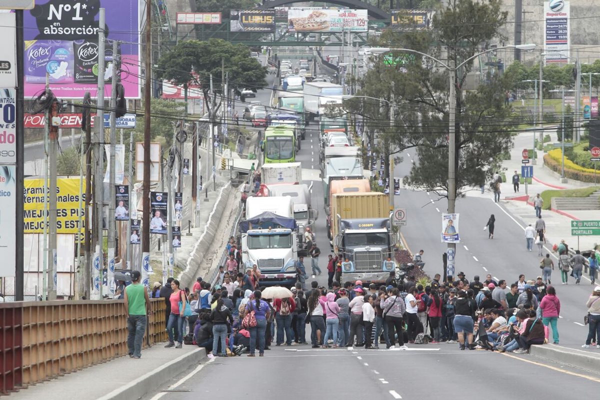 Maestros bloquean el paso vehicular en el puente Belice, provocando con ello un atasco y que usuarios del transporte público desciendan y tengan que caminar para llegar a sus destinos. (Foto Prensa Libre: Érick Ávila)