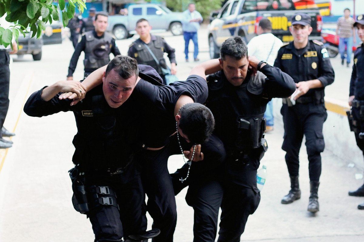 Uno de los agentes policiales heridos es auxiliado por sus compañeros en Jocotán, Chiquimula. (Foto Prensa Libre: Edwin Paxtor)