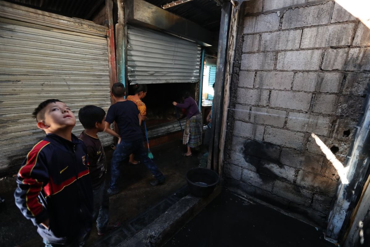 Niños observan cómo quedaron los locales consumidos por el fuego. (Foto Prensa Libre: Esbin García)