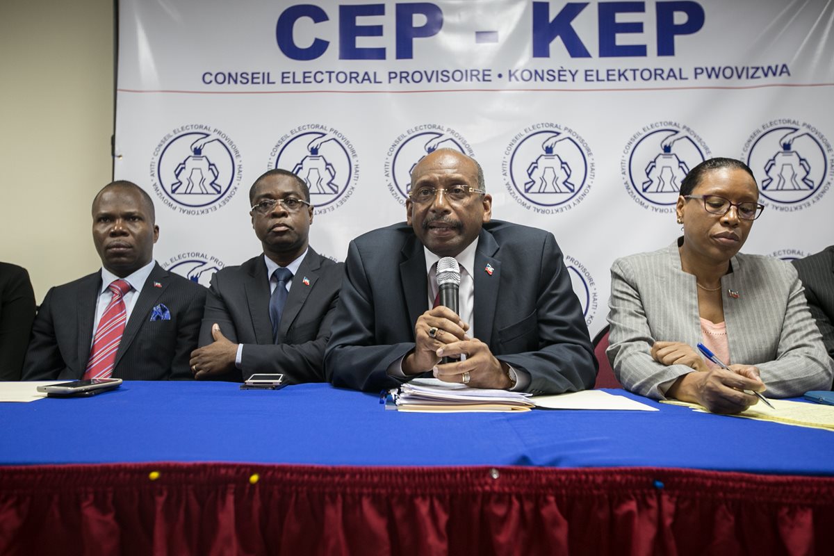 El presidente del comité electoral, Leopold Berlanger (2d), anuncia la agenda electoral próxima de Haití. (Foto Prensa Libre: EFE).