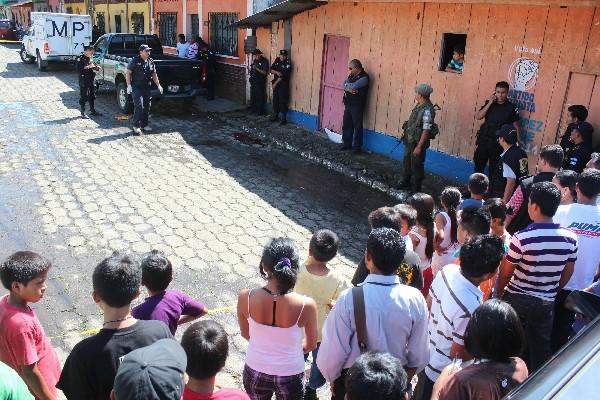 Policías y fiscales del MP revisan el lugar donde fue atacado a balazos el alcalde de San Gabriel, Suchitepéquez, René López y López, quien murió en un centro asistencial privado de Mazatenango.