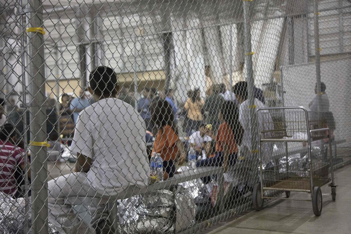 Inmigrantes detenidos en McAllen, Texas, donde se ve a varios niños. (Foto Prensa Libre: AFP)